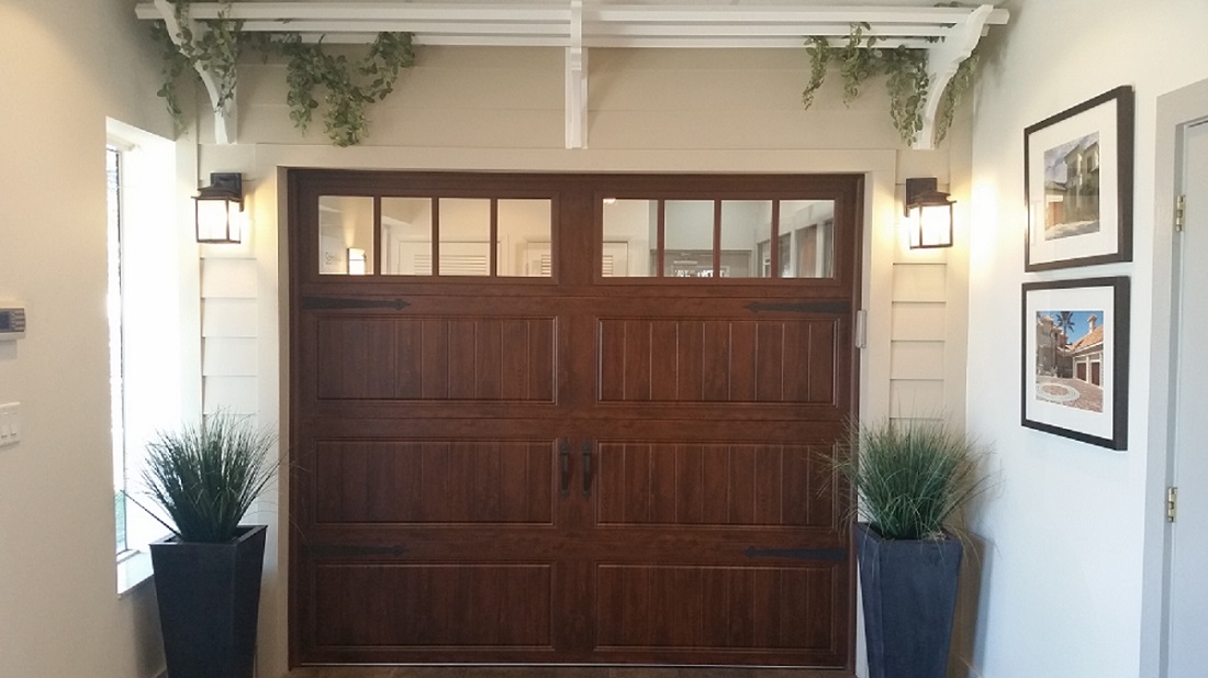 Brown, wooden Clopay garage door with windows in our Tampa showroom